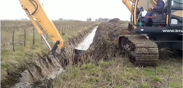 retroexcavadora haciendo canal de drenaje