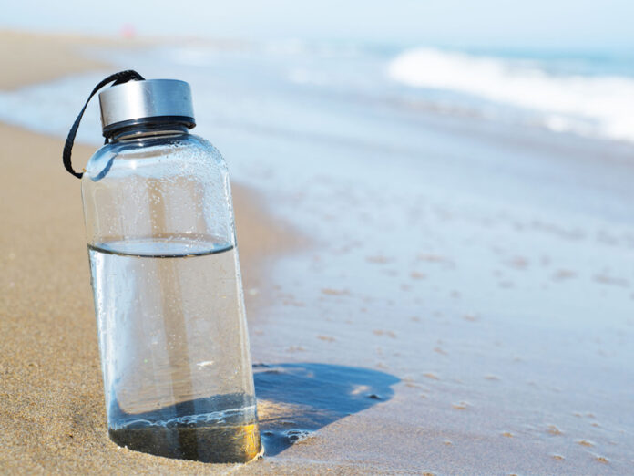 reusable water bottle on the beach
